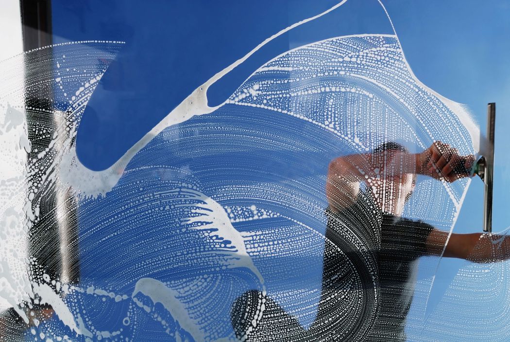 man cleaning a glass window