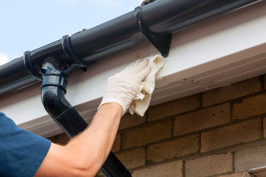 man cleaning the facia and soffit of a roof